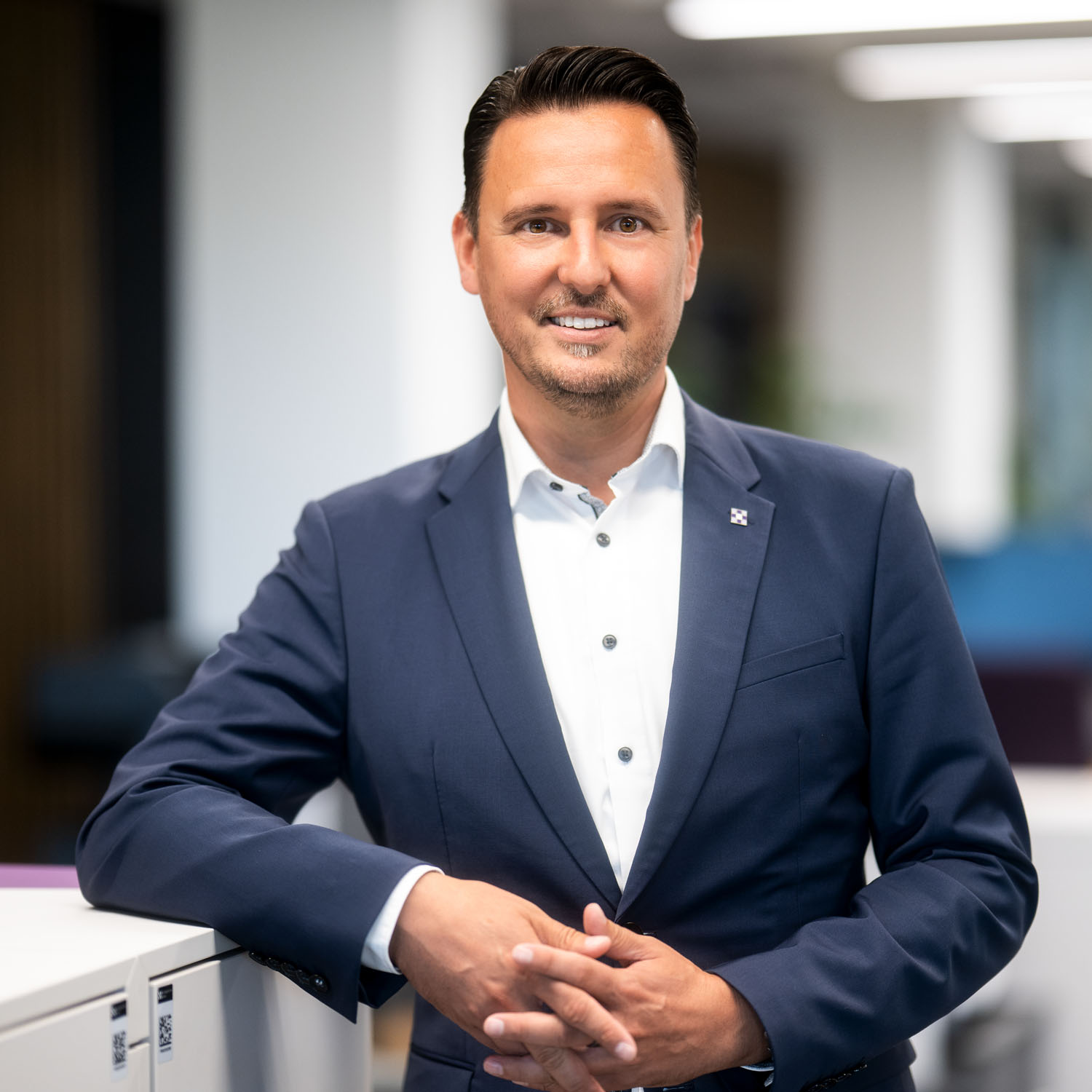 Andreas Hagemann am Arbeitsplatz, er lächelt in die Kamera.