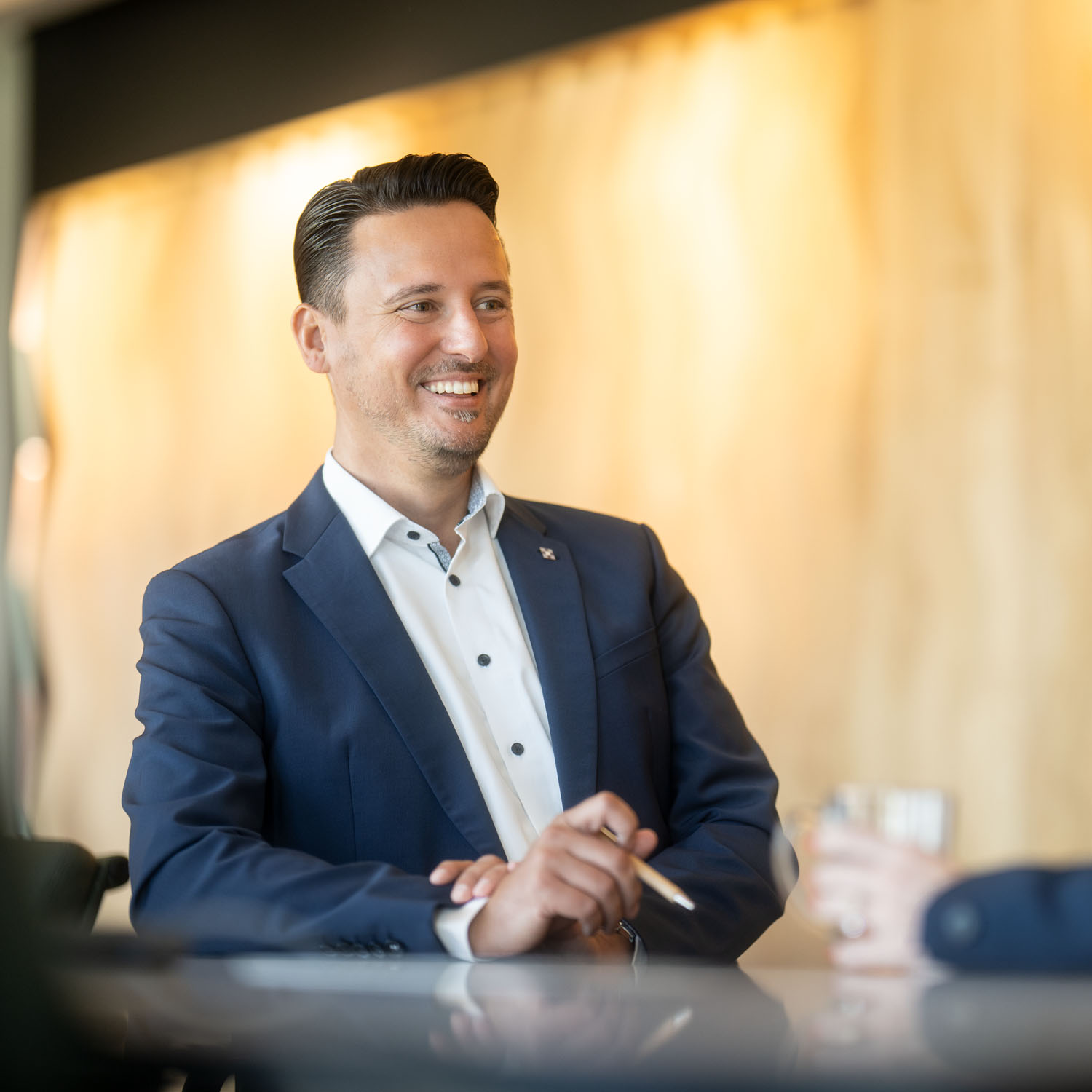 Andreas Hagemann im Kundengespräch. Er lächelt zu einer Person die außerhalb des Bildes ist.