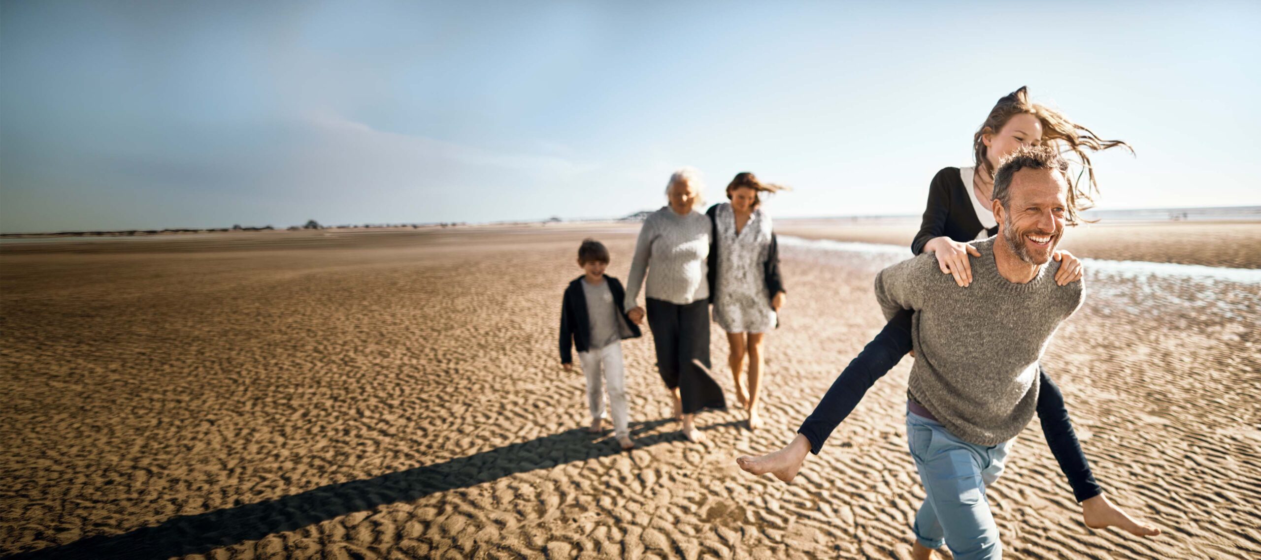 Eine Familie mit Großmutter macht einen Strandspaziergang
